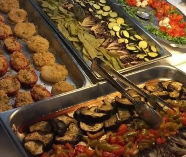 Buffet con verdure grigliate, insalate fresche e pietanze impanate.