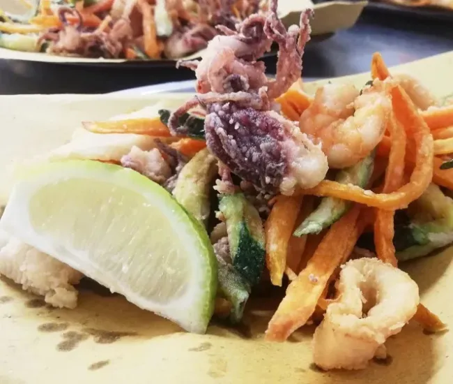 Frittura mista di pesce e verdure con spicchio di limone.